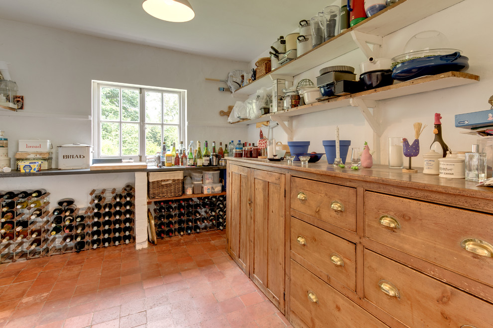 This is an example of a country wine cellar in Other with brick floors and storage racks.