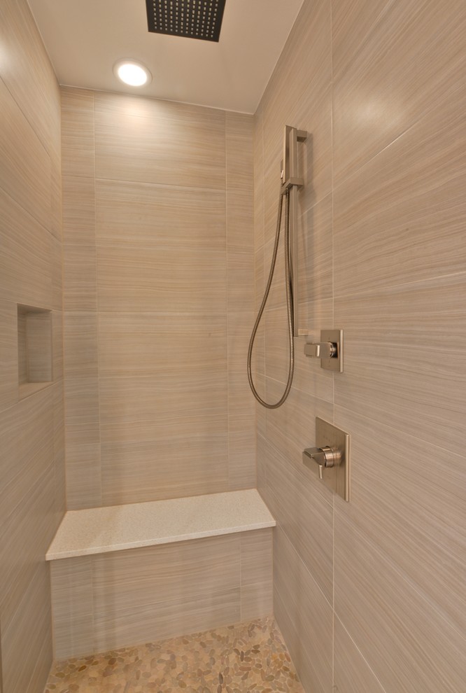 Inspiration for a small contemporary master beige tile and porcelain tile pebble tile floor alcove shower remodel in Houston with an undermount sink, flat-panel cabinets, light wood cabinets, solid surface countertops, a one-piece toilet and beige walls
