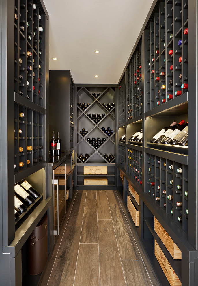 Photo of a transitional wine cellar in Essex with storage racks.