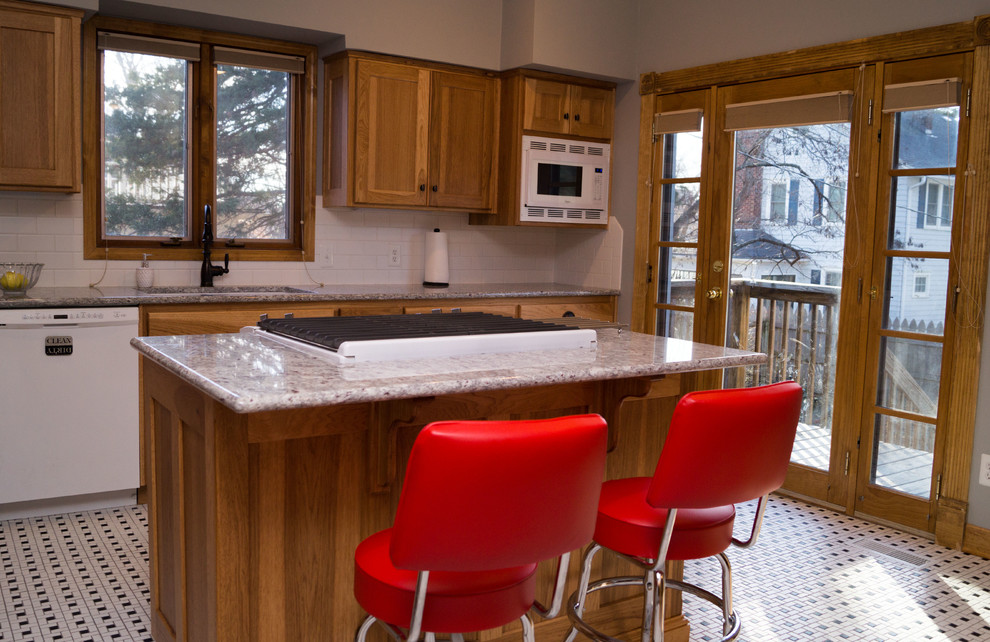 Enclosed kitchen - mid-sized victorian ceramic tile enclosed kitchen idea with an undermount sink, shaker cabinets, light wood cabinets, granite countertops, white backsplash, ceramic backsplash, white appliances and an island