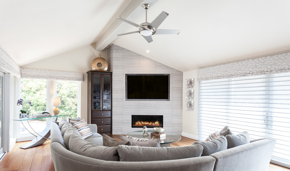 Design ideas for a large transitional open concept family room in Sacramento with beige walls, medium hardwood floors, a ribbon fireplace, a tile fireplace surround and a wall-mounted tv.