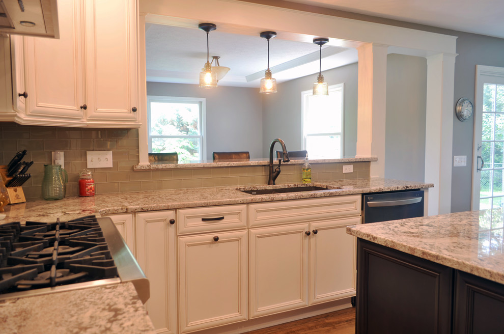 Eat-in kitchen - large transitional u-shaped medium tone wood floor eat-in kitchen idea with an undermount sink, recessed-panel cabinets, white cabinets, granite countertops, beige backsplash, ceramic backsplash, stainless steel appliances and an island