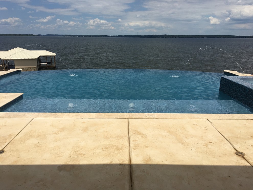 Mid-sized transitional backyard concrete and custom-shaped infinity hot tub photo in Austin