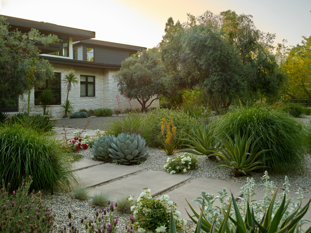 Photo of a southwestern drought-tolerant and desert front yard concrete paver and metal fence landscaping in Sacramento for summer.