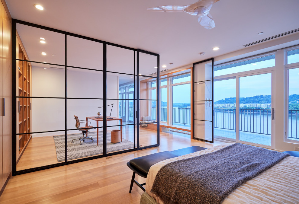 Imagen de dormitorio actual grande con paredes blancas y suelo de madera clara