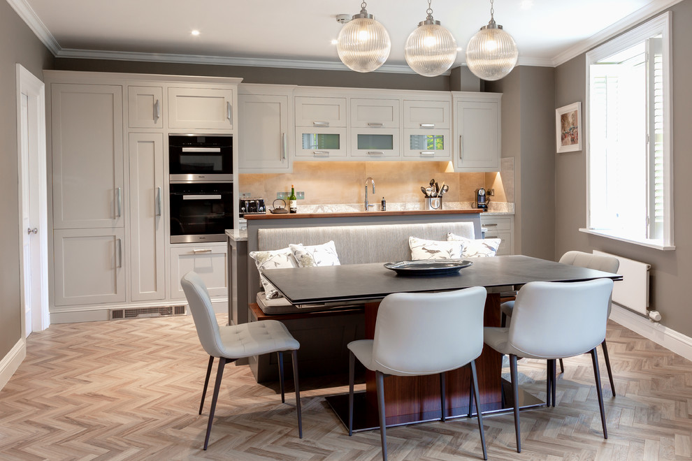 Inspiration for a transitional kitchen in Dublin with a drop-in sink, solid surface benchtops, beige splashback, black appliances, vinyl floors and with island.