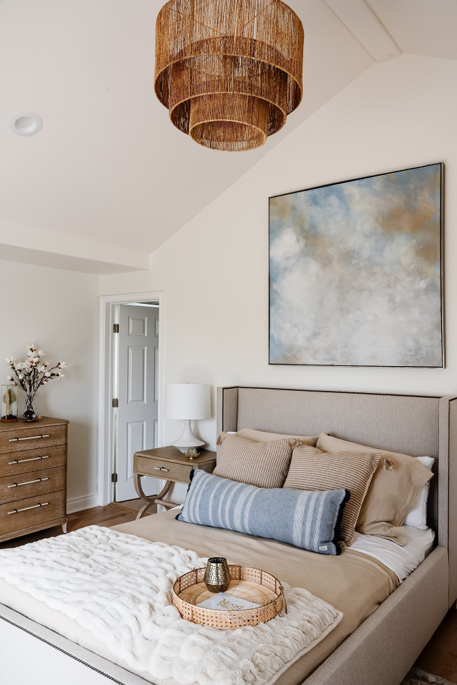 This is an example of a medium sized coastal guest bedroom in Los Angeles with white walls, medium hardwood flooring, beige floors and a vaulted ceiling.
