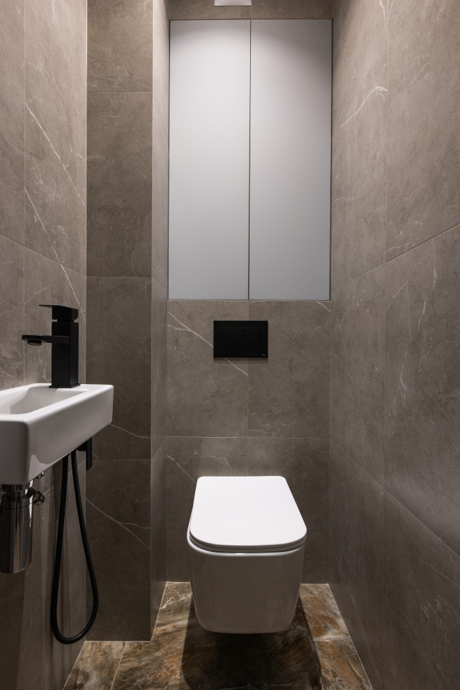 Immagine di un bagno di servizio design con WC sospeso e pareti grigie