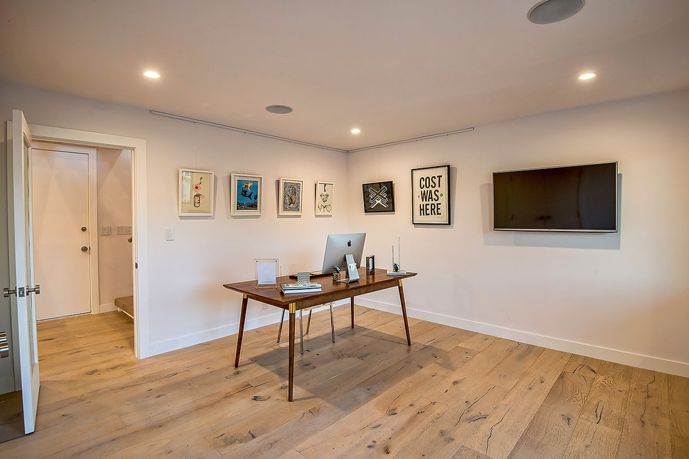 Photo of a mid-sized contemporary study room in Los Angeles with white walls, light hardwood floors, no fireplace and a freestanding desk.