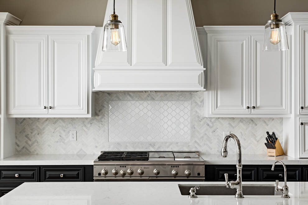 Inspiration for a large transitional l-shaped light wood floor and brown floor open concept kitchen remodel in Phoenix with an undermount sink, raised-panel cabinets, black cabinets, quartz countertops, white backsplash, marble backsplash, stainless steel appliances and an island