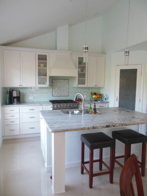Mid-sized transitional l-shaped porcelain tile and white floor eat-in kitchen photo in San Diego with an undermount sink, shaker cabinets, white cabinets, quartz countertops, green backsplash, subway tile backsplash, stainless steel appliances and an island