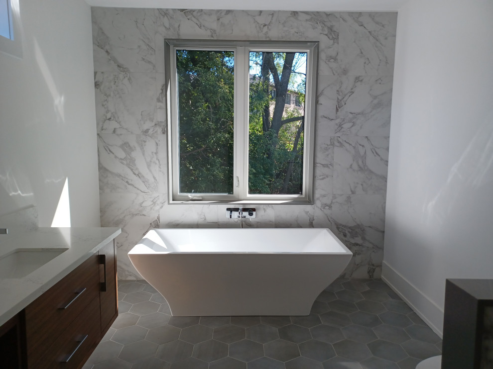 Photo of a large modern 3/4 wet room bathroom in Toronto with a freestanding tub, a one-piece toilet, white tile, stone tile, white walls, ceramic floors, an undermount sink, quartzite benchtops, black floor, an open shower, white benchtops, a double vanity and a built-in vanity.