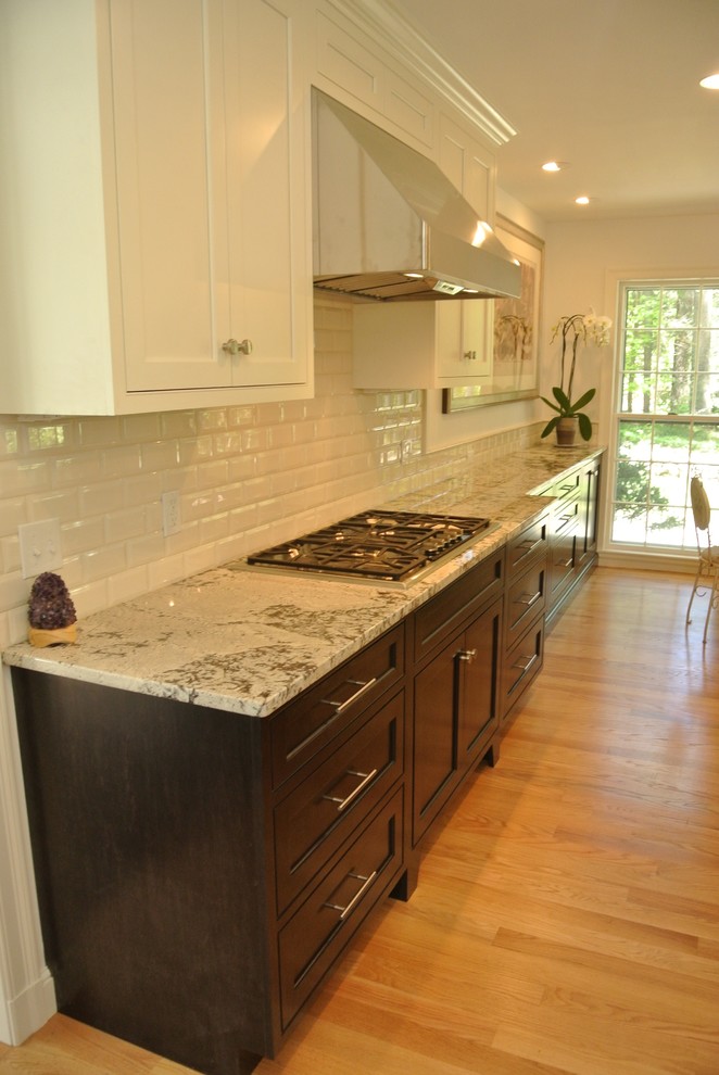 Inspiration for a transitional light wood floor eat-in kitchen remodel in Boston with an undermount sink, shaker cabinets, granite countertops, white backsplash, subway tile backsplash, stainless steel appliances and an island