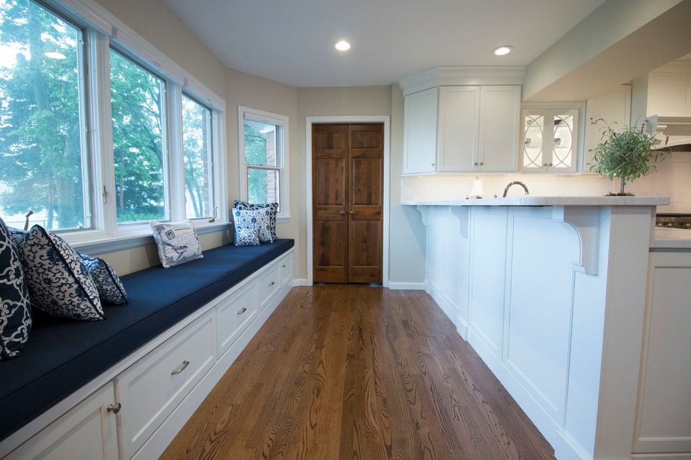 Inspiration for a huge transitional medium tone wood floor open concept kitchen remodel with an undermount sink, shaker cabinets, white cabinets, marble countertops, white backsplash, ceramic backsplash, stainless steel appliances and two islands