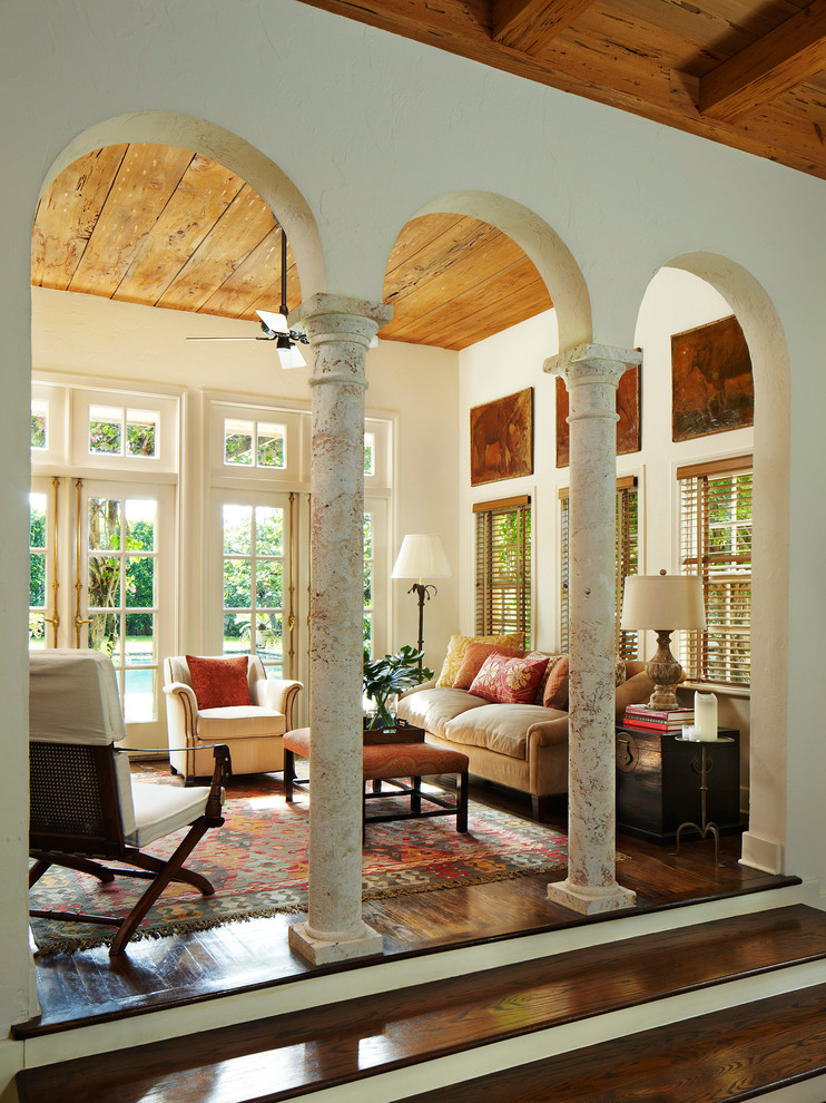 This is an example of a mediterranean living room in Miami with beige walls and dark hardwood floors.