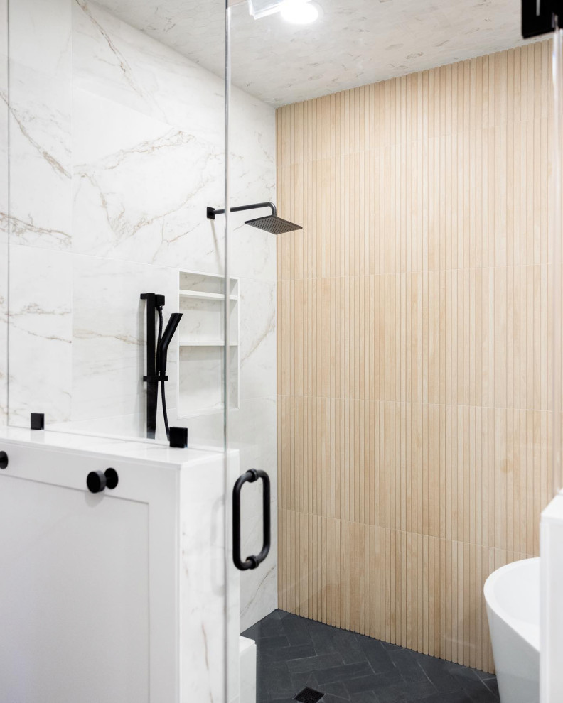 Design ideas for a mid-sized traditional master wet room bathroom in Las Vegas with flat-panel cabinets, light wood cabinets, a freestanding tub, white walls, ceramic floors, an undermount sink, black floor, a hinged shower door, white benchtops, a single vanity, a built-in vanity, brown tile and wood-look tile.