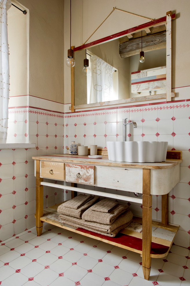 Inspiration for a country powder room in Other with furniture-like cabinets, white tile, red tile, ceramic tile, beige walls, ceramic floors, a vessel sink, wood benchtops, multi-coloured floor, distressed cabinets and brown benchtops.