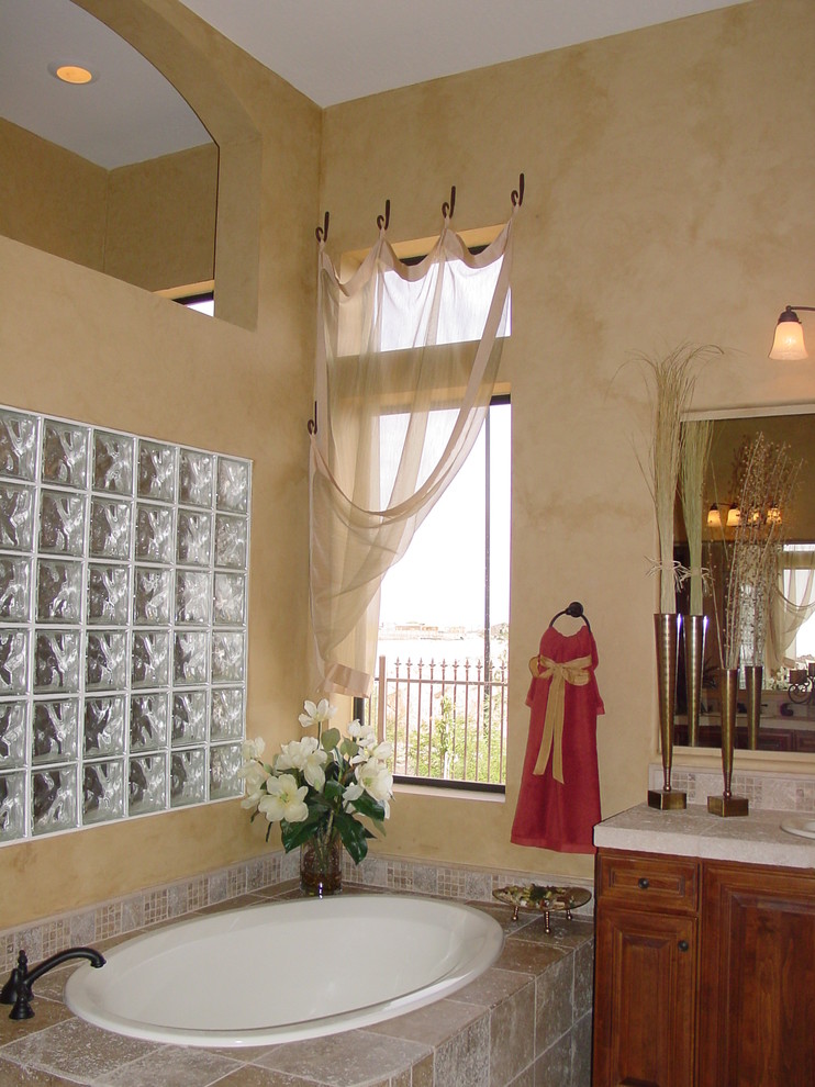 Doorless shower - mid-sized transitional master beige tile and stone tile ceramic tile doorless shower idea in Phoenix with raised-panel cabinets, dark wood cabinets, a hot tub, a one-piece toilet, beige walls and a drop-in sink