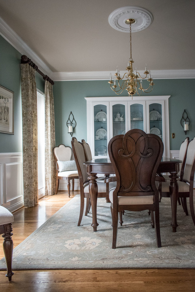 Example of a mid-sized transitional medium tone wood floor and brown floor enclosed dining room design in Louisville with blue walls