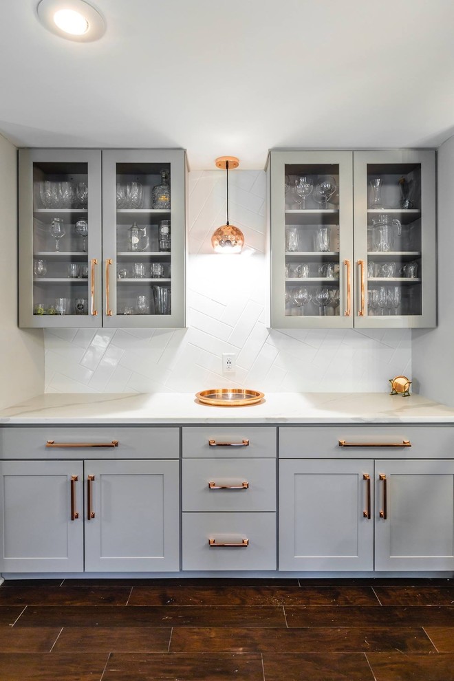 This is an example of a large modern single-wall kitchen pantry in Boston with a single-bowl sink, raised-panel cabinets, grey cabinets, marble benchtops, white splashback, ceramic splashback, stainless steel appliances, ceramic floors, with island, brown floor and white benchtop.