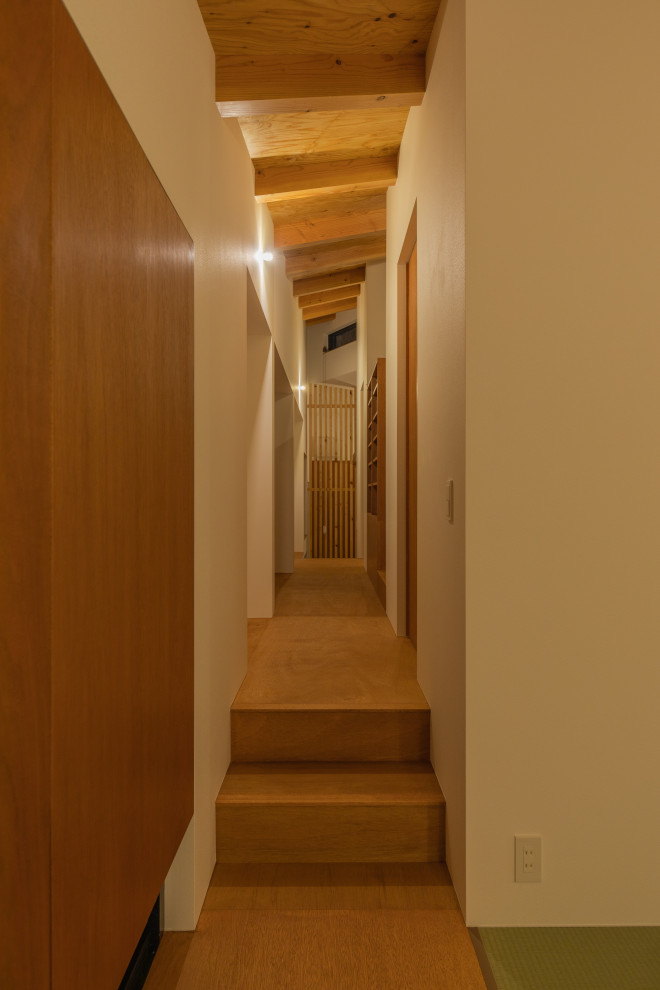 Idee per un piccolo ingresso o corridoio moderno con pareti marroni, pavimento in legno massello medio, pavimento marrone, soffitto in carta da parati e carta da parati