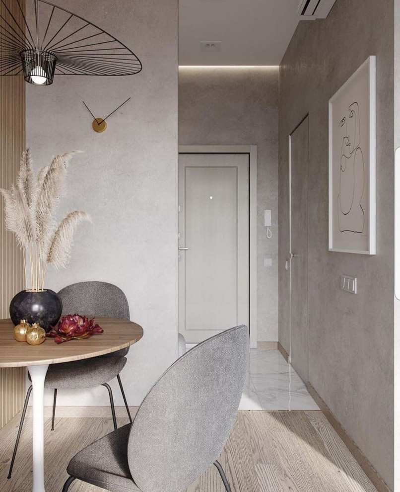 Стильный дизайн: маленькая двухуровневая гостиная комната в современном стиле с серыми стенами, светлым паркетным полом, телевизором на стене, бежевым полом и панелями на стенах для на участке и в саду - последний тренд