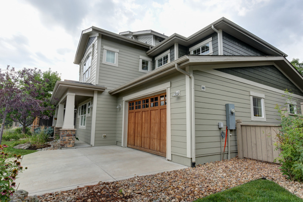 This is an example of a mid-sized arts and crafts two-storey beige house exterior in Denver with concrete fiberboard siding, a gable roof, a shingle roof, a black roof and clapboard siding.