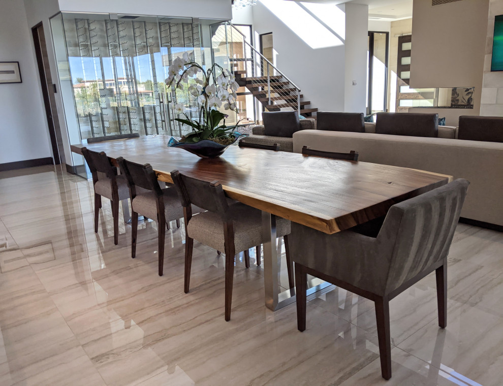 Immagine di un'ampia sala da pranzo aperta verso il soggiorno moderna con pareti bianche, pavimento in gres porcellanato, camino bifacciale e pavimento beige