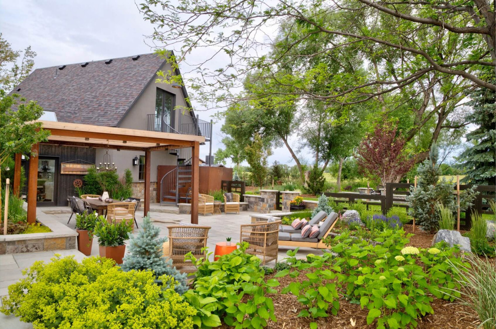 Idee per un grande giardino country dietro casa in estate con pavimentazioni in pietra naturale e recinzione in metallo