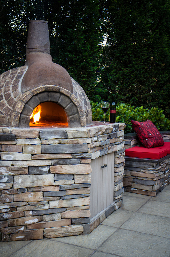 Example of a mountain style backyard concrete paver full sun patio design