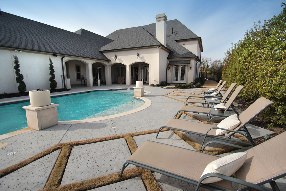 Design ideas for a large traditional backyard custom-shaped pool in Dallas with stamped concrete.