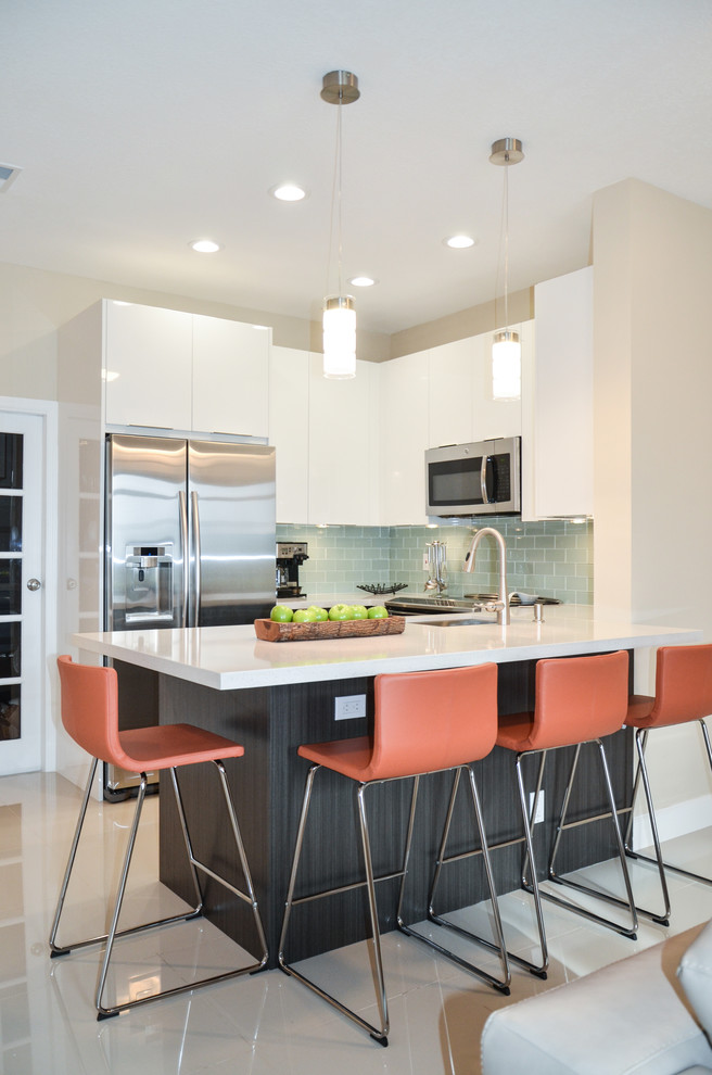 Small trendy u-shaped eat-in kitchen photo in Miami with an undermount sink, flat-panel cabinets, white cabinets, quartz countertops, white backsplash, subway tile backsplash and stainless steel appliances