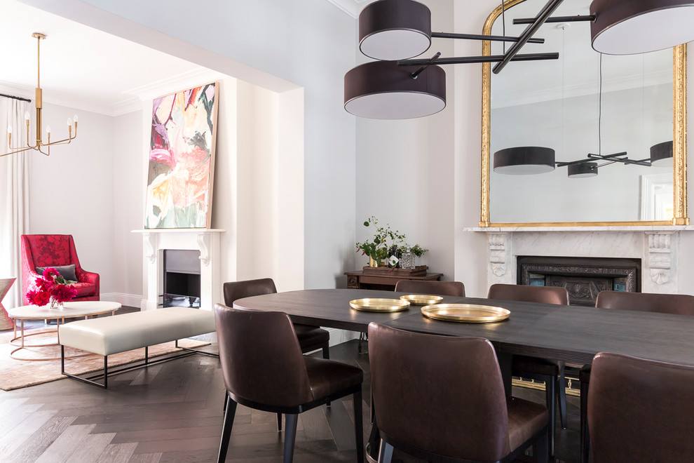 Contemporary separate dining room in Sydney with white walls, dark hardwood floors, a standard fireplace and brown floor.