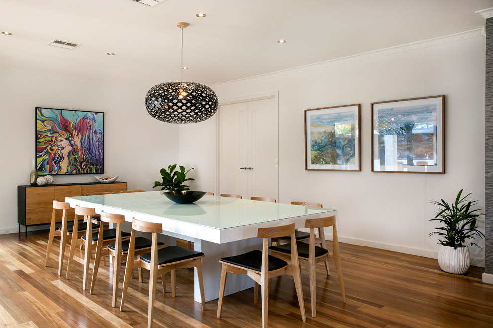 Contemporary separate dining room in Adelaide with white walls, medium hardwood floors and brown floor.