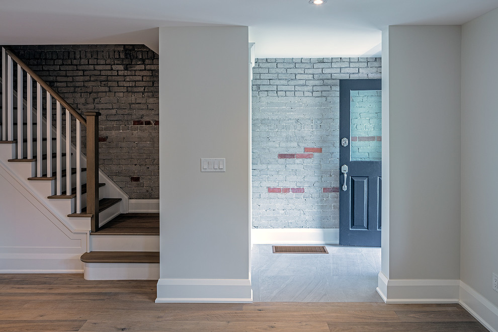 Photo of a small transitional vestibule in Toronto with grey walls, light hardwood floors, a single front door, a blue front door and beige floor.