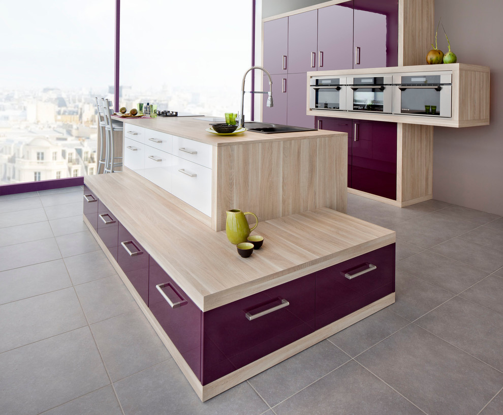 This is an example of a mid-sized modern galley open plan kitchen in Le Havre with an undermount sink, purple cabinets, laminate benchtops, stainless steel appliances, ceramic floors, with island and grey floor.