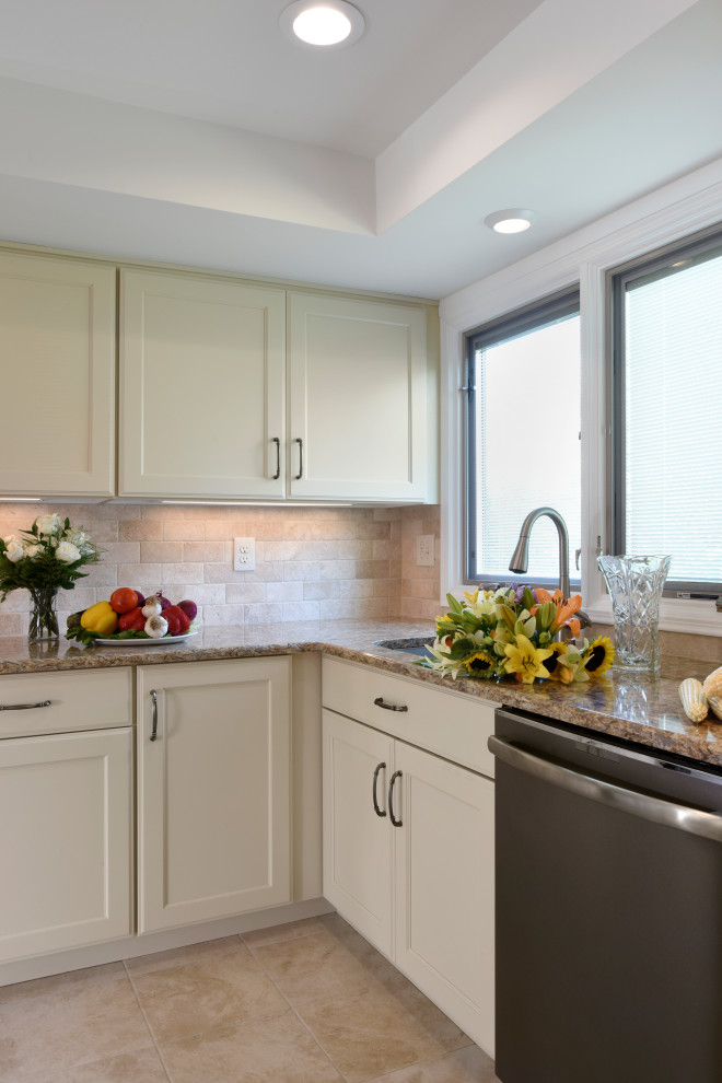 Inspiration for a mid-sized transitional u-shaped porcelain tile, beige floor and tray ceiling enclosed kitchen remodel with an undermount sink, flat-panel cabinets, beige cabinets, quartz countertops, beige backsplash, travertine backsplash, black appliances, an island and beige countertops