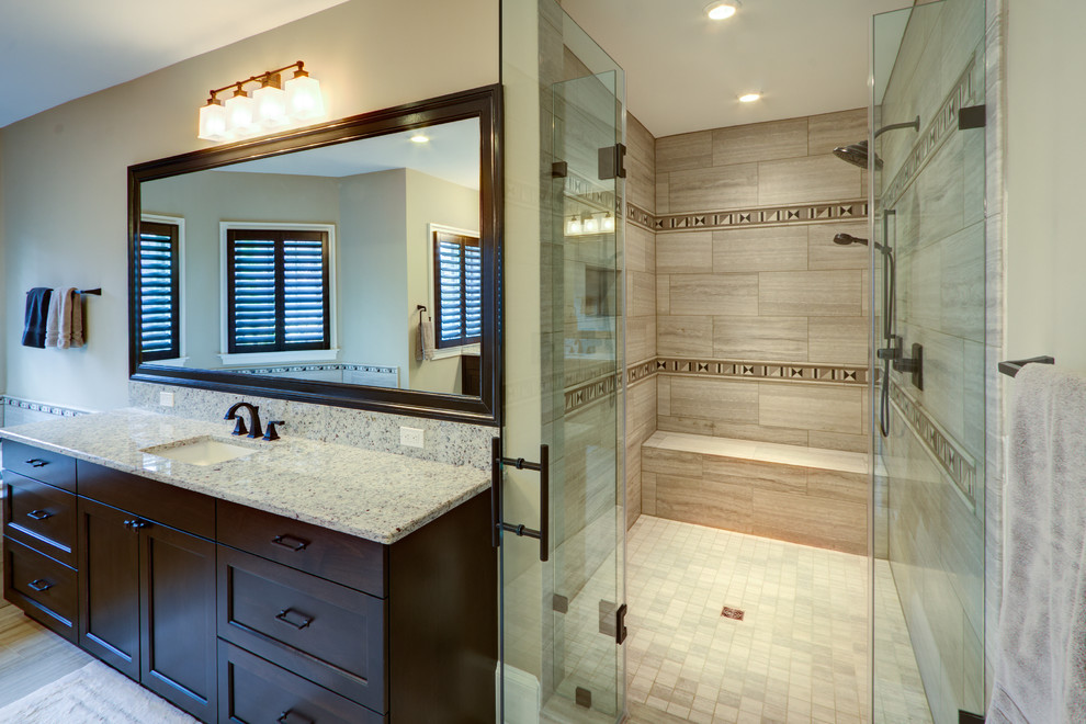 Example of a transitional beige tile and ceramic tile ceramic tile drop-in bathtub design in DC Metro with an undermount sink, beaded inset cabinets, dark wood cabinets, granite countertops and gray walls