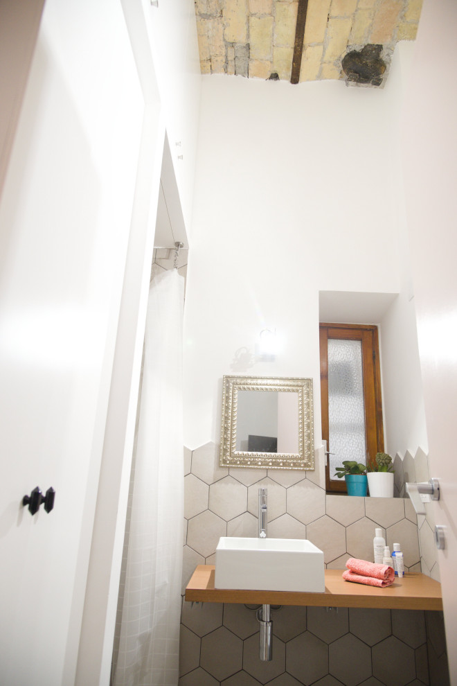 Immagine di una piccola stanza da bagno con doccia industriale con ante in legno chiaro, piastrelle di cemento, pareti bianche, pavimento in cementine, lavabo a bacinella, pavimento grigio, doccia con tenda, lavanderia, un lavabo, mobile bagno sospeso, soffitto a volta e WC sospeso