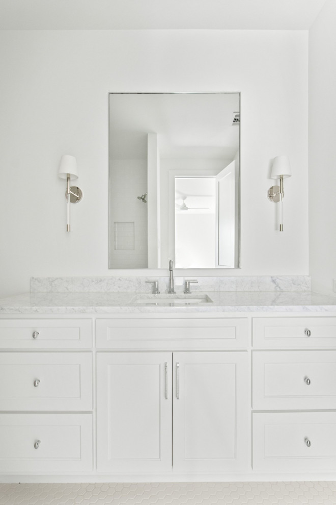 Photo of a nautical family bathroom in Dallas with beaded cabinets, white cabinets, an alcove shower, a two-piece toilet, white tiles, metro tiles, white walls, porcelain flooring, a submerged sink, marble worktops, white floors, a hinged door, grey worktops, a single sink and a freestanding vanity unit.