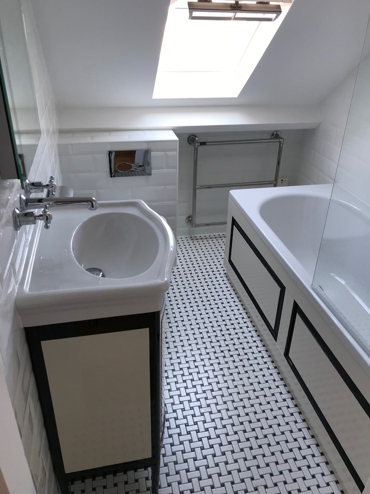 This is an example of a mid-sized contemporary kids wet room bathroom in London with furniture-like cabinets, white cabinets, a one-piece toilet, ceramic tile, white walls, mosaic tile floors, a wall-mount sink, white floor and an open shower.