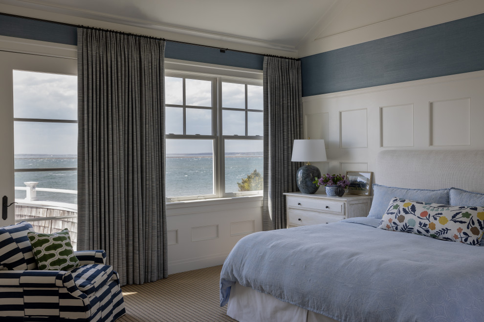 This is an example of a mid-sized beach style guest bedroom in Boston with blue walls, carpet, beige floor, vaulted and decorative wall panelling.