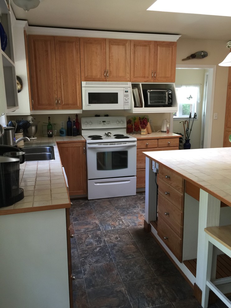 Photo of a large eclectic l-shaped eat-in kitchen in Vancouver with raised-panel cabinets, medium wood cabinets, tile benchtops and with island.