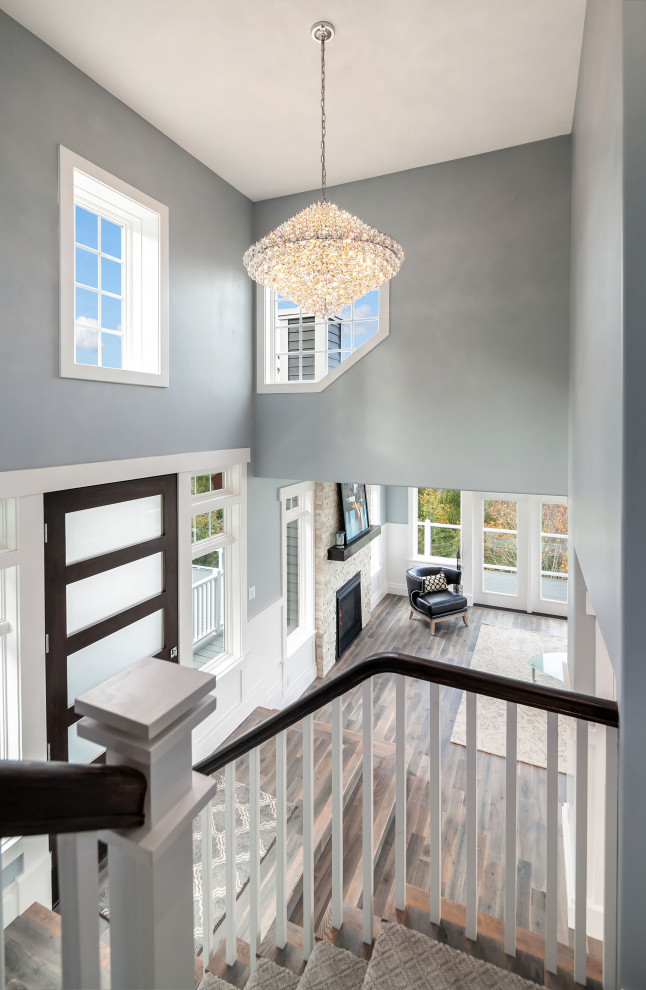 Photo of a large classic foyer in Seattle with blue walls, light hardwood flooring, a single front door, a dark wood front door, grey floors, exposed beams and wainscoting.