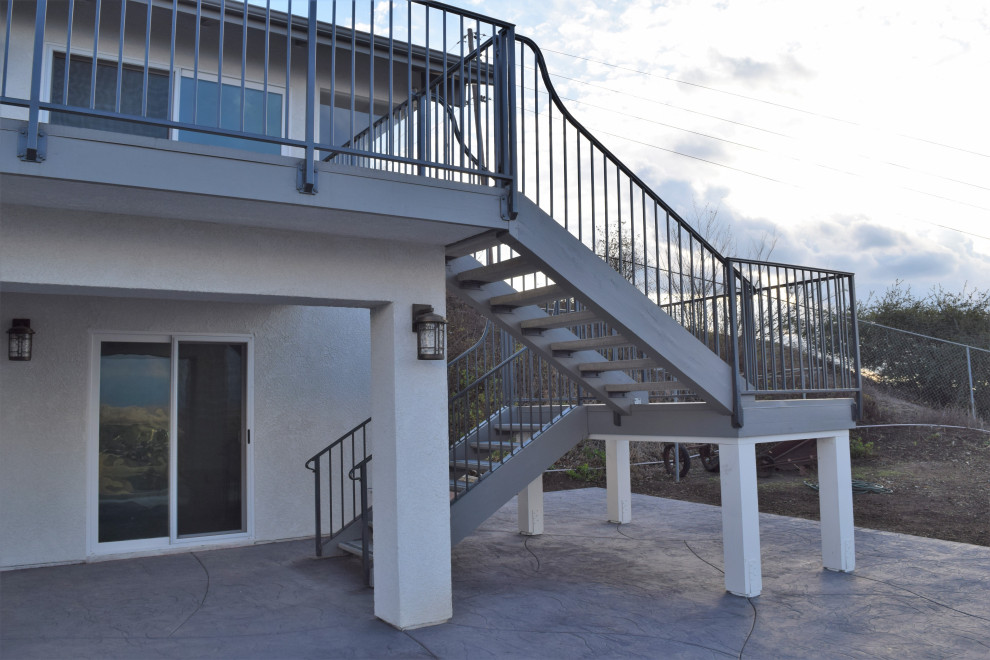 Imagen de escalera en U actual de tamaño medio sin contrahuella con escalones de hormigón y barandilla de metal