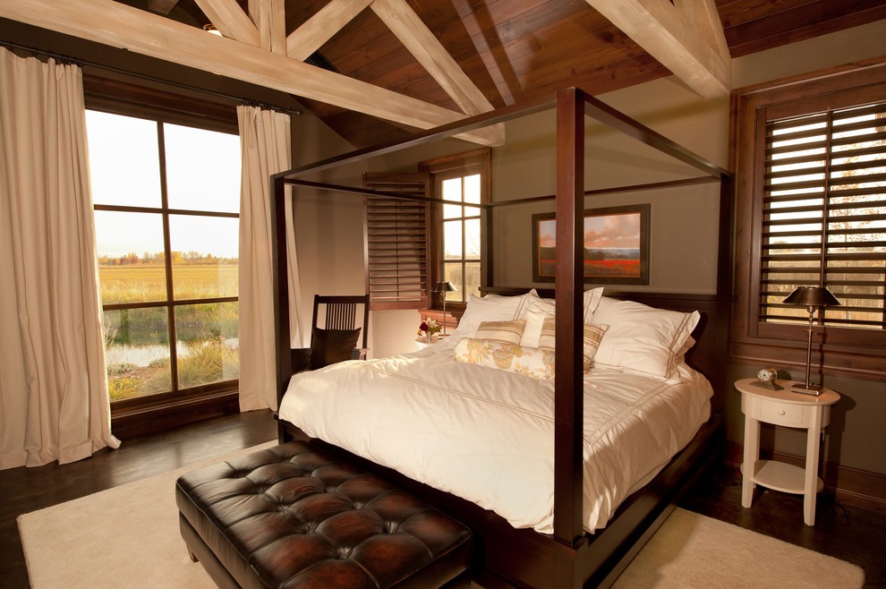 Country bedroom in Other with brown walls and dark hardwood floors.