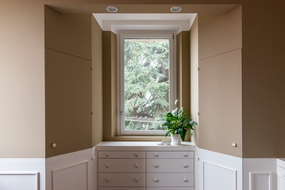 Стильный дизайн: маленькая гардеробная комната унисекс в современном стиле с фасадами с выступающей филенкой, белыми фасадами, полом из керамической плитки и многоуровневым потолком для на участке и в саду - последний тренд