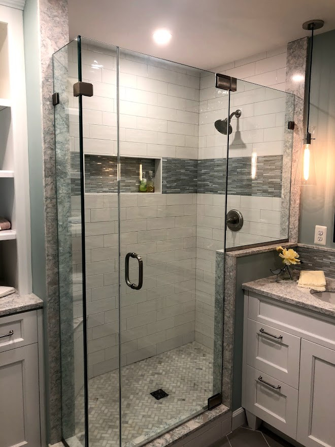 Design ideas for a mid-sized transitional master bathroom in Baltimore with recessed-panel cabinets, white cabinets, an alcove shower, a one-piece toilet, white tile, subway tile, blue walls, ceramic floors, an undermount sink, engineered quartz benchtops, grey floor, a hinged shower door, multi-coloured benchtops, a shower seat, a double vanity and a freestanding vanity.