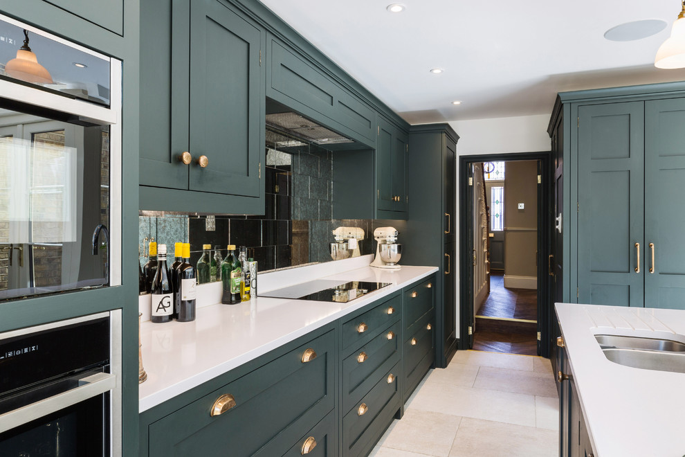 This is an example of a large traditional l-shaped eat-in kitchen in London with an integrated sink, shaker cabinets, green cabinets, quartzite benchtops, metallic splashback, glass tile splashback, panelled appliances, limestone floors, with island, white floor and white benchtop.