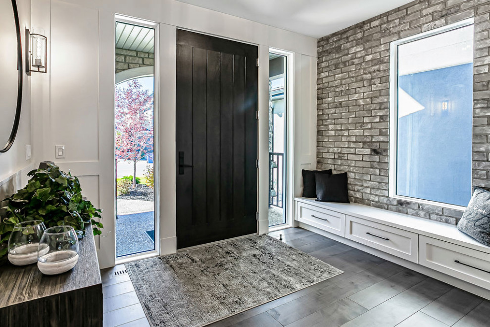 Inspiration for a transitional gray floor and light wood floor foyer remodel in Calgary with white walls and a black front door